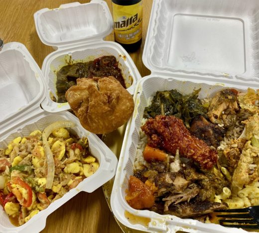 Assorted Jamaican dishes including ackee and saltfish, stewed chicken, and fried festival served in takeout containers — representing local restaurants and caterers benefiting from WILCO’s MSME business loans.